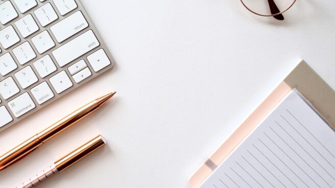 A Mac Keyboard And Pens With A Piece Of Paper Denoting Someone About To Write A Cv